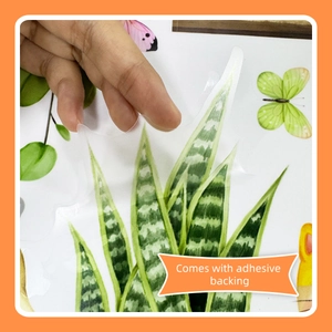 Close-up showing the adhesive backing of a cartoon green plant wall sticker
