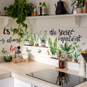 Detalle de vinilo decorativo de cocina con plantas verdes y frase Love is secret ingredient