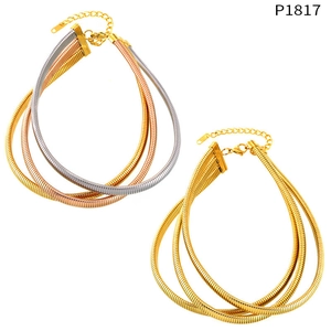 Detailed view of layered snake chains in triple-tone and gold finishes with lobster clasp