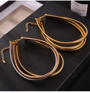 Detailed view of layered 18K gold snake bone chains with lobster clasp and logo tag