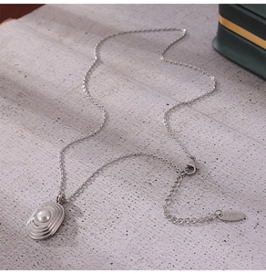 Détail macro du collier en acier inoxydable doré 18 carats avec pendentif en perle