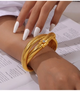 Detailed view of wide 18K gold plated spiral cuff bracelet featuring a central zircon stone
