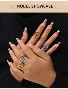 Close-up of vintage starburst rings with natural stones worn over black sweater sleeves
