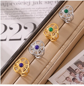 Retro compass rings with blue and green gemstones on a premium leather display stand