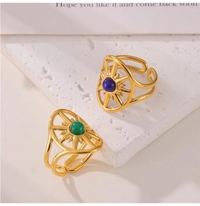 Detailed shot of retro gold-plated sun-shaped rings with blue and green stones