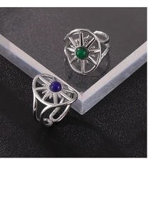 Detail of vintage eight-pointed star ring with green and blue natural stones in silver finish