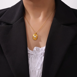 Collier élégant en titane plaqué or 18k avec pendentif perle géométrique sur un mannequin