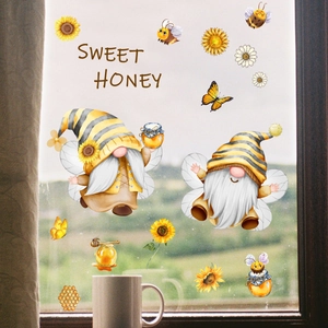 Close-up of bee and gnome window stickers with Sweet Honey text on a glass surface