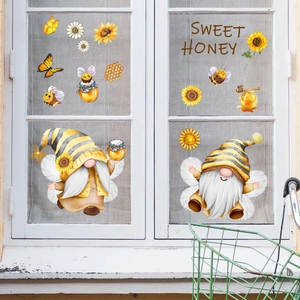 Detail of bee gnome window stickers and sunflowers on a glass window pane
