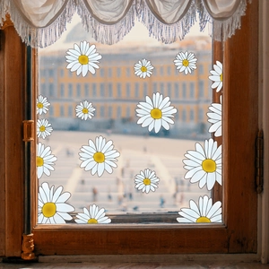 Detail of diverse white daisy window stickers on glass with a vintage wooden frame