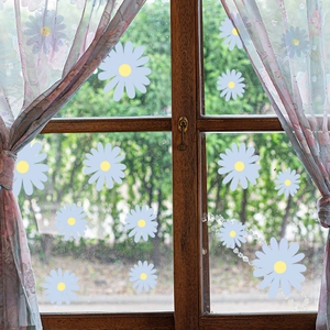 Detail of light blue daisy glass stickers with yellow centers on a wooden window pane