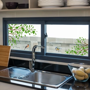 Détail de stickers électrostatiques avec feuilles vertes et oiseaux dans une cuisine