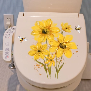 Détail de stickers décoratifs tournesols et abeilles sur un couvercle de toilette