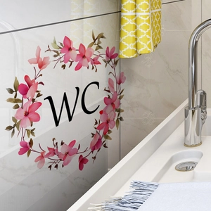 Sticker WC floral avec fleurs roses et feuilles vertes sur une cloison de salle de bain