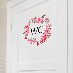 Sticker WC floral avec fleurs roses et feuilles vertes sur une porte en bois blanc