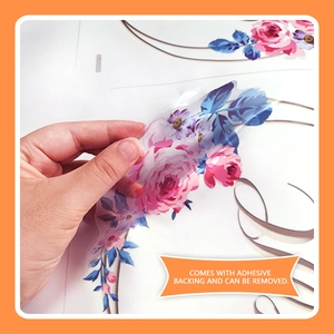 Détail de l'autocollant floral pour WC montrant la face adhésive et le film amovible