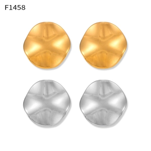 Detailed macro view of uneven round earrings in matte gold and silver finish