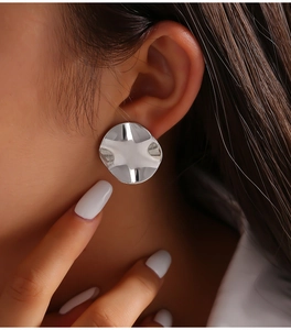 Macro shot of silver irregular round stud earrings with a liquid metal fold texture