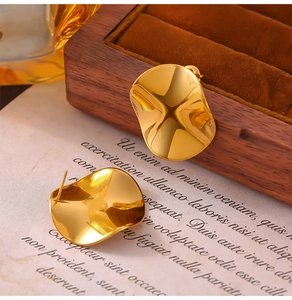 Detail view of irregular wavy 18K gold plated titanium steel earrings with mirror finish