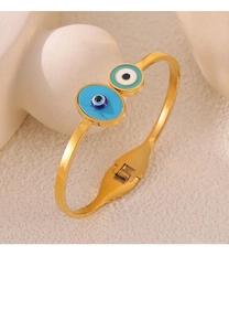 Detail of gold evil eye spring bangle with blue enamel charms and hinge mechanism