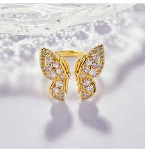 Gros plan sur une bague papillon dorée avec zircons et ombre créative en forme d'aile