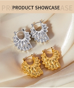 Détail de boucles d'oreilles pétales en or et argent sur un tissu en soie élégant