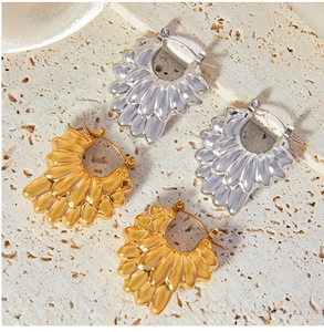 Détail de boucles d'oreilles pétales évidés dorées et argentées à texture ondulée