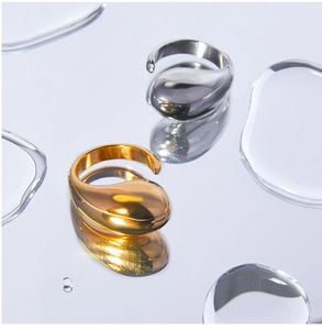 Macro view of gold and silver teardrop rings with highly polished mirror finish