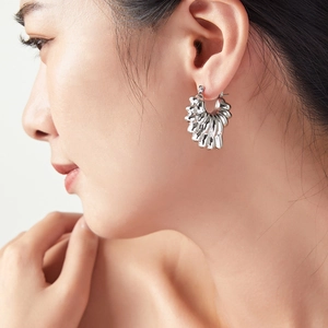 Boucles d'oreilles créoles bohèmes argentées avec texture plissée et forme de pétale