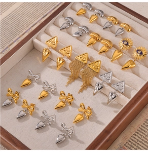 Detail van 18k gouden geometrische evil eye en kwastjes oorbellen in een doosje