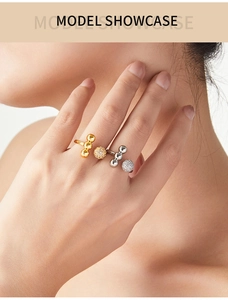 Detail of model wearing gold and silver open rings with pave diamond spherical beads