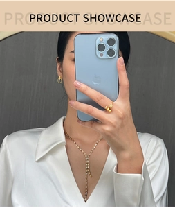 Detailed view of luxury gold spherical ring and Y-shaped necklace on female model