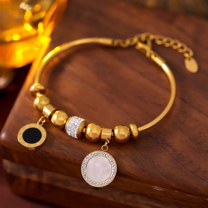 Bracelet doré avec pendentif chiffres romains et nacre sur présentoir en bois