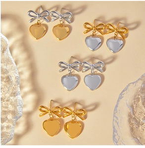 Détail de quatre paires de boucles d'oreilles nœud et cœur en acier 18K doré et argenté