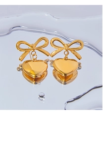 Macro d'oreilles en or 18 carats avec nœud et pendentif cœur sur fond texturé