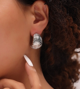 Gros plan sur la boucle d'oreille vintage en titane avec détails de texture nervurée