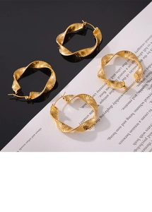 Detail of four golden U-shaped twisted earrings with fine dotted hollow texture