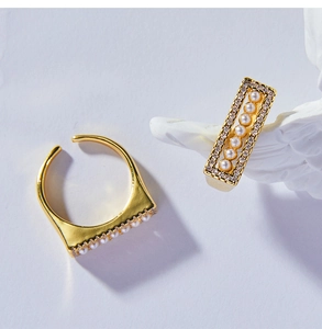 Detail of gold geometric open ring featuring a rectangular pearl row and pavé crystals