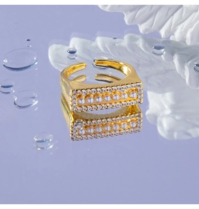Detail of adjustable gold ring with small white pearls and micro-set zircon accents