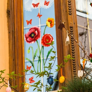 Red flower and butterfly window stickers on glass with sky background home decor