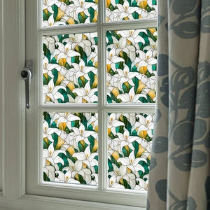 Detail of elegant lily floral stained glass window film on white wooden frame