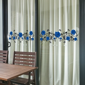 Blue rose flower wall stickers applied to glass balcony doors in a bright home setting