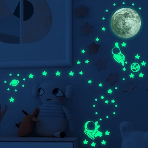 Luminous astronaut and planet wall stickers glowing green in a dark kids room