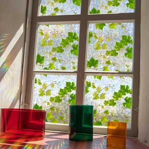 Rainbow mosaic window film with green vine pattern casting colorful light on a windowsill