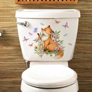 Detail of cute hand-drawn fox and butterfly stickers applied to white ceramic toilet tank