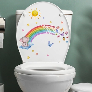 Detail of colorful rainbow and elephant stickers with motivational text on white toilet lid