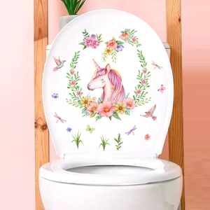 Close-up of pink unicorn and floral decal on a white bathroom toilet lid