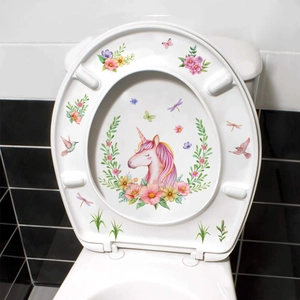 Close-up of watercolor unicorn and floral decals on a white bathroom toilet lid