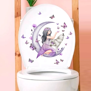 Detail view of cartoon anime girl and wolf stickers on a white toilet lid in a pink bathroom
