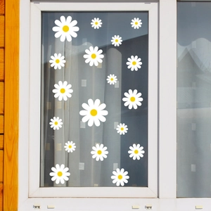 Detail of white daisy window stickers with yellow centers on a glass pane in a home